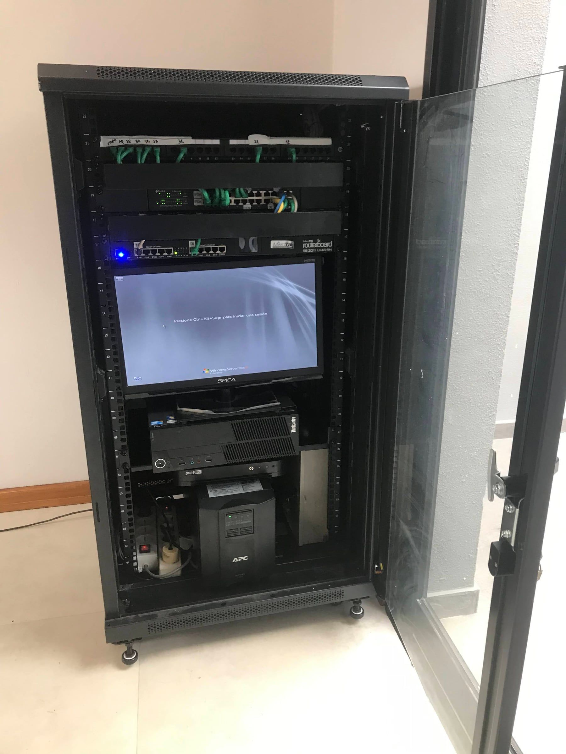 Compact edge cabinet — patch panel, switch, MikroTik RouterBOARD and UPS in a wall-mounted rack.